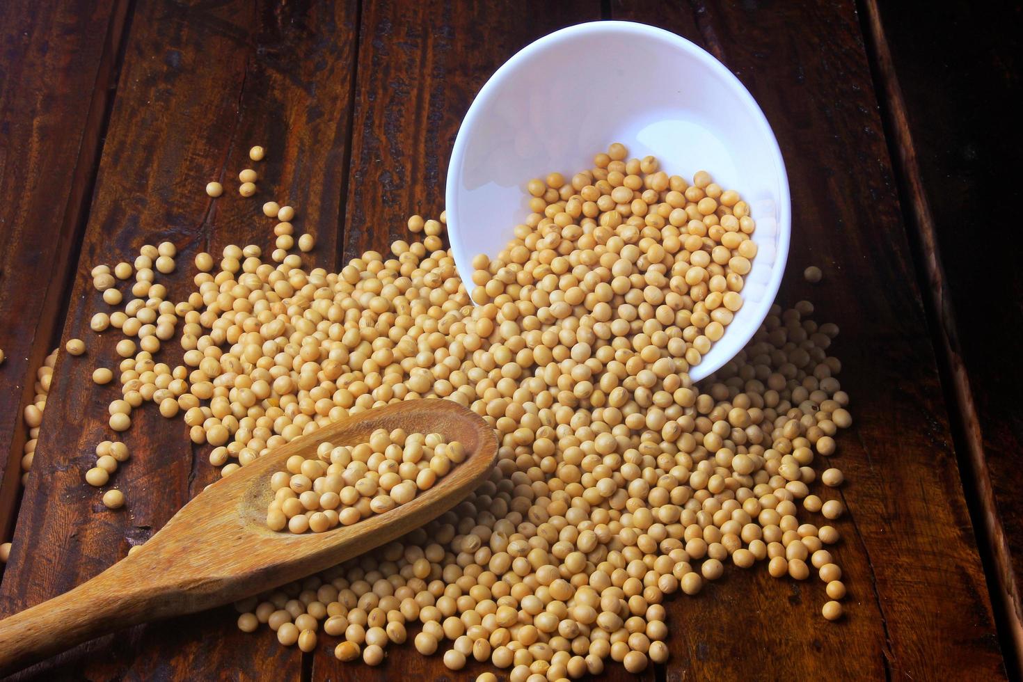 raw and fresh soy beans inside white ceramic bowl on rustic wooden table. Close up photo