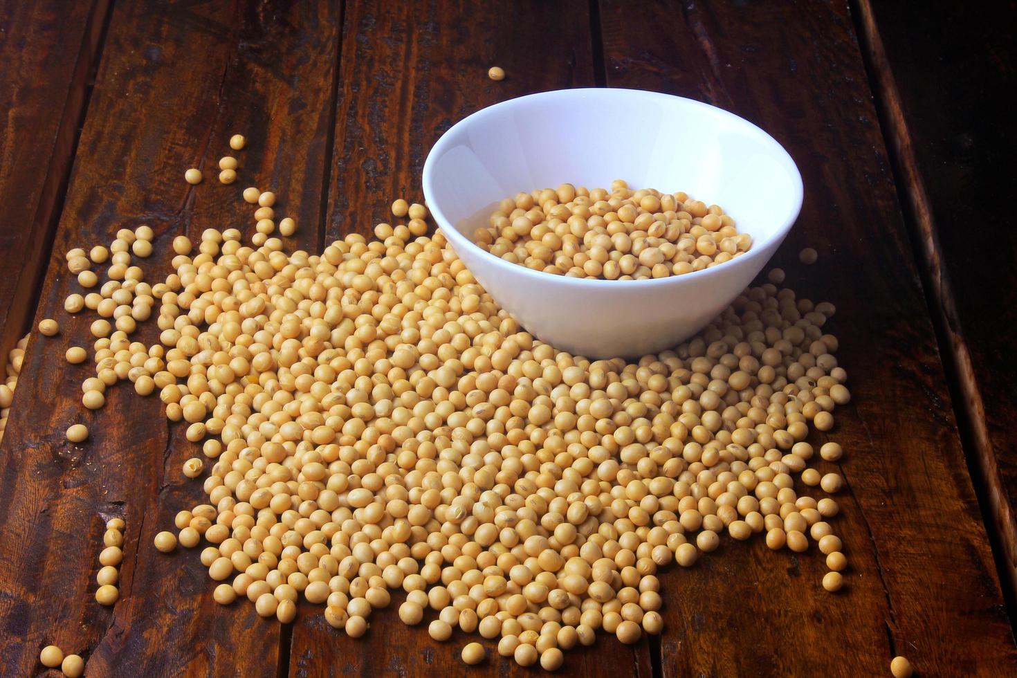 raw and fresh soy beans inside white ceramic bowl on rustic wooden table. Close up photo