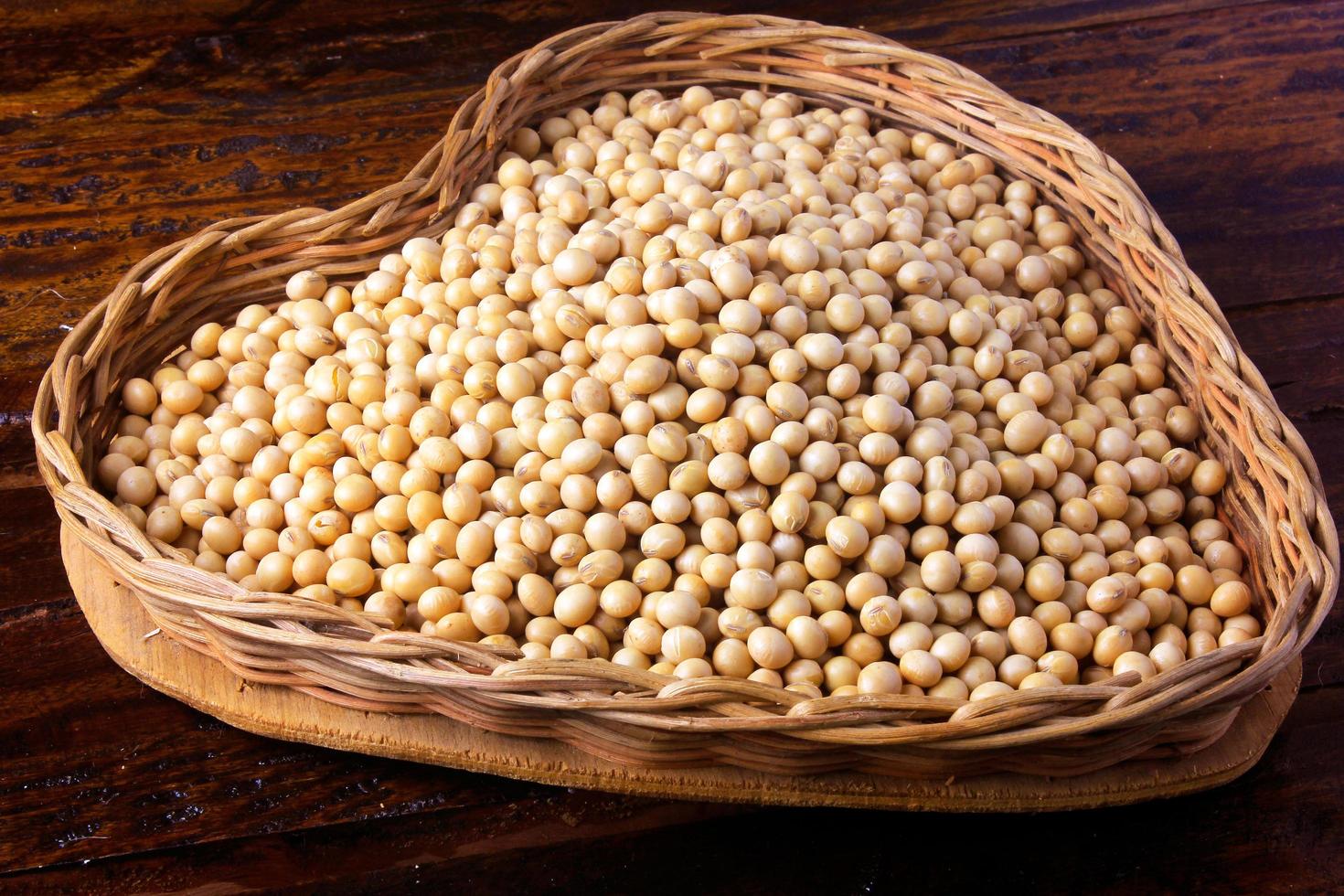 raw and fresh soy beans inside basket with heart shape on rustic wooden table. Closeup photo