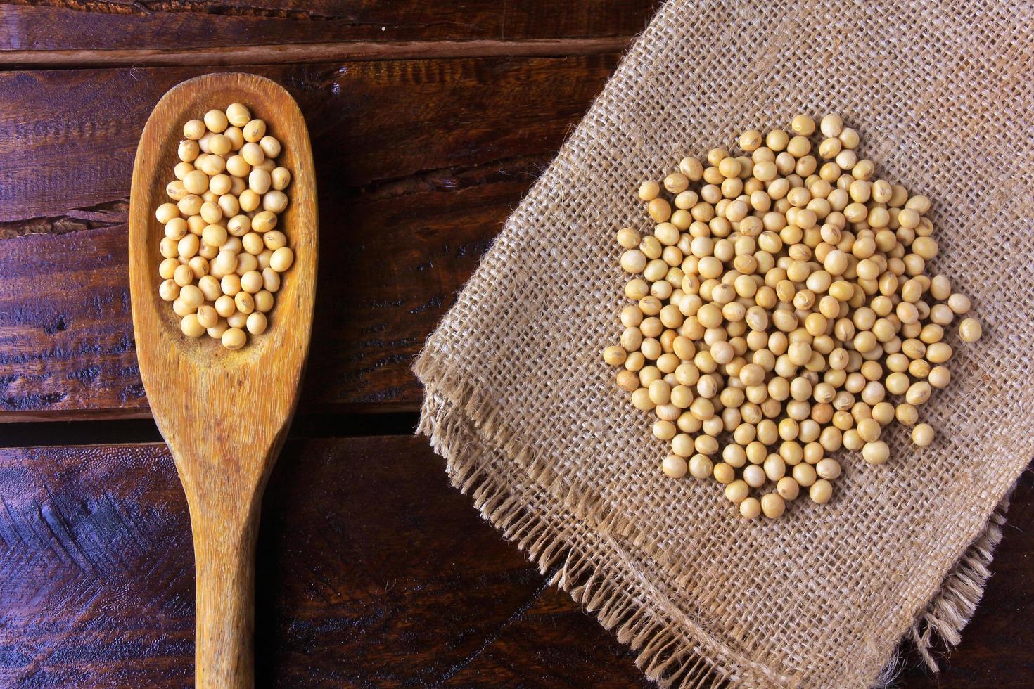 raw and fresh soy beans on rustic fabric on rustic wooden table. Closeup photo