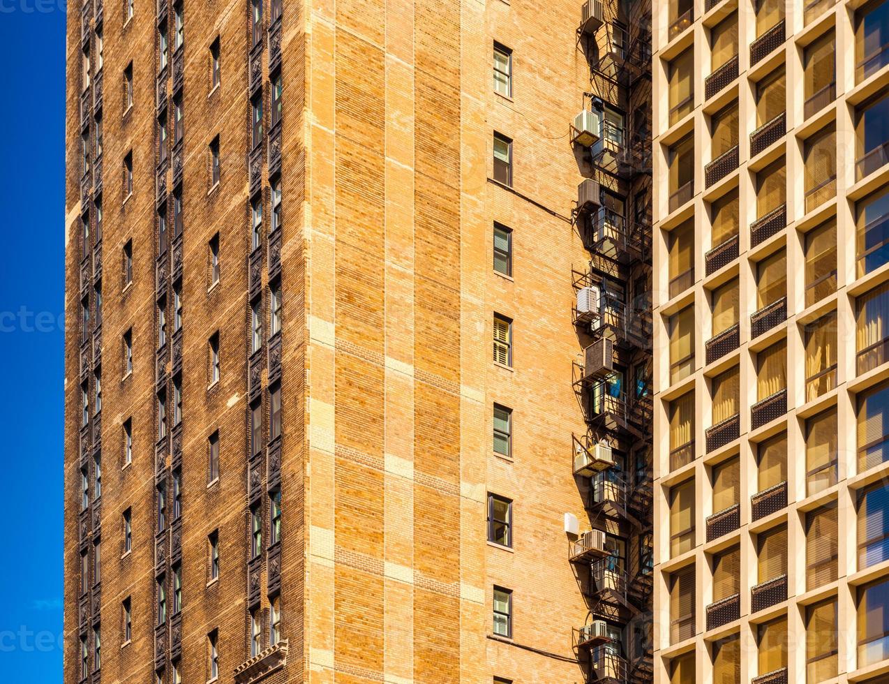 Block of flats in Chicago, apartment building in downtown against the blue sky, house made of brown bricks photo