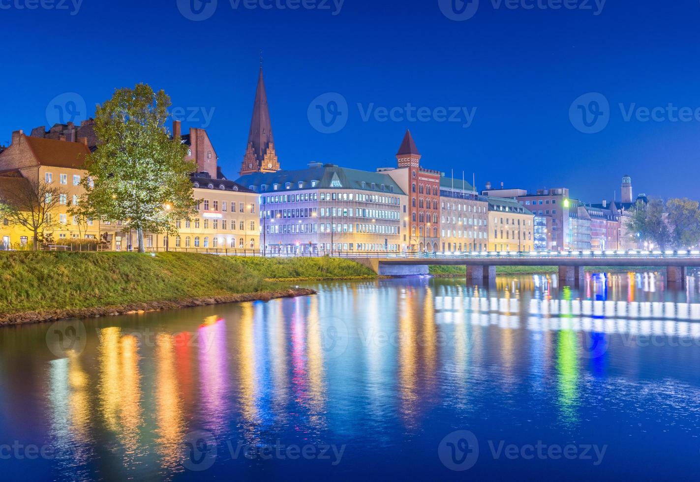 vista nocturna de la ciudad. paisaje urbano de malmo en la noche, suecia. hermosa ciudad europea reflejada en el agua foto