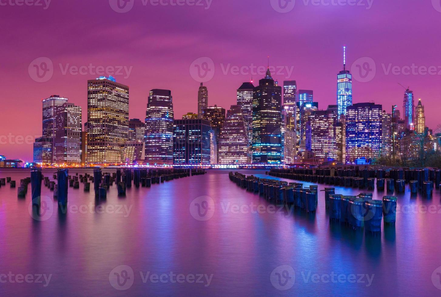 Manhattan en la noche con reflejos multicolores en el agua, vista desde Brooklyn, Nueva York, EE. foto