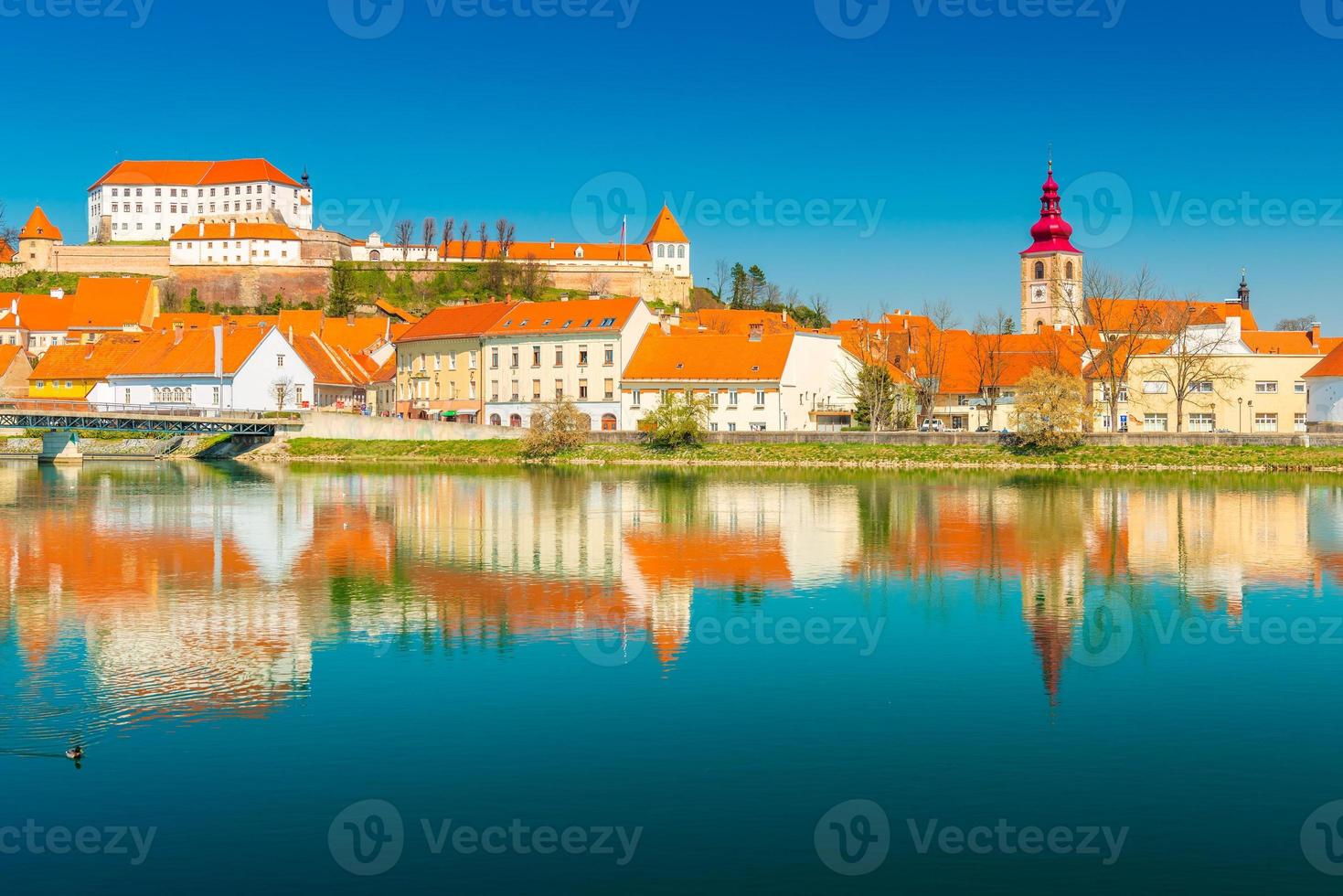 Hermoso paisaje urbano de ptuj reflejado en el agua, Eslovenia foto