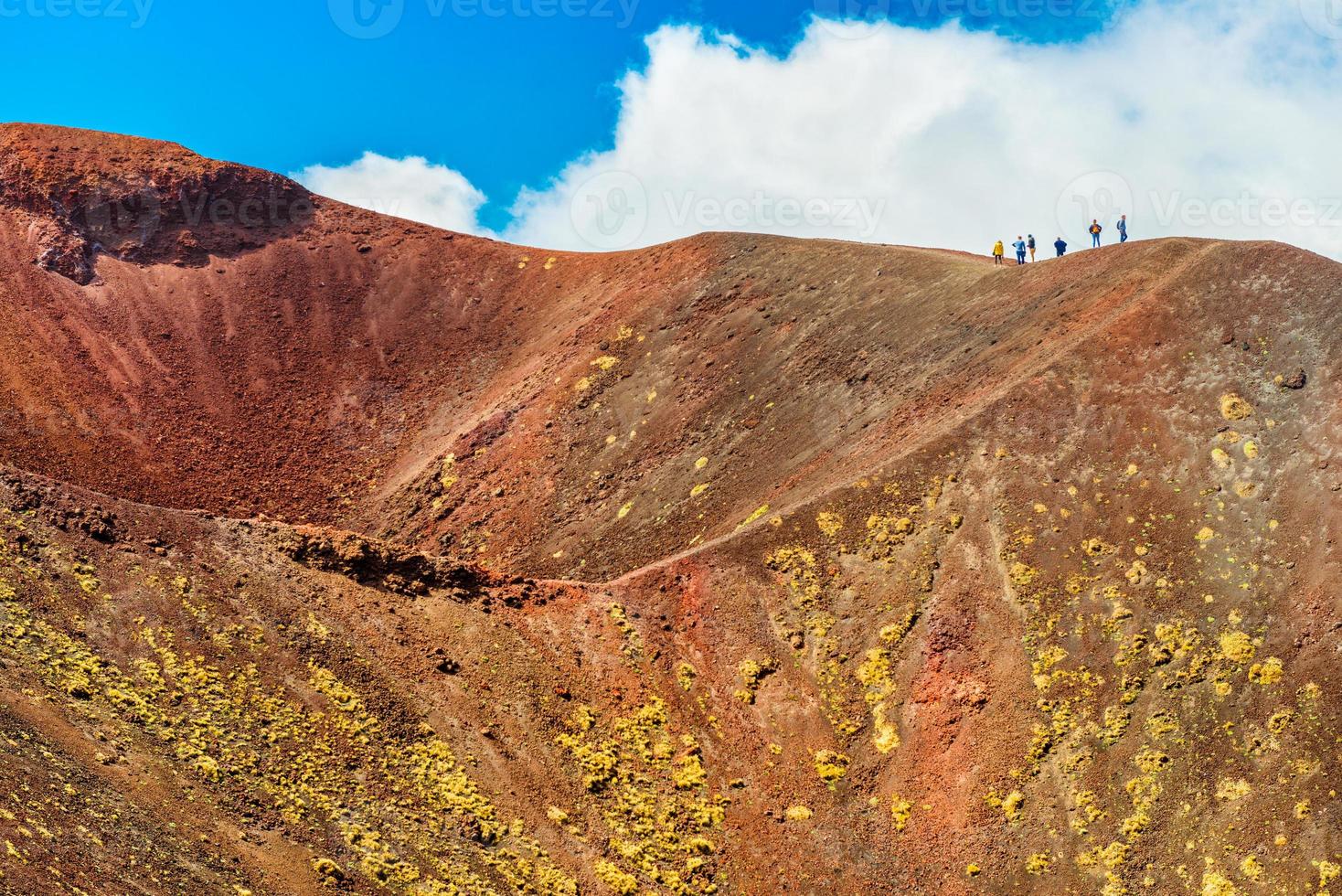 Un grupo de personas de pie en el borde del cráter del volcán, el monte Etna, Sicilia, Italia foto