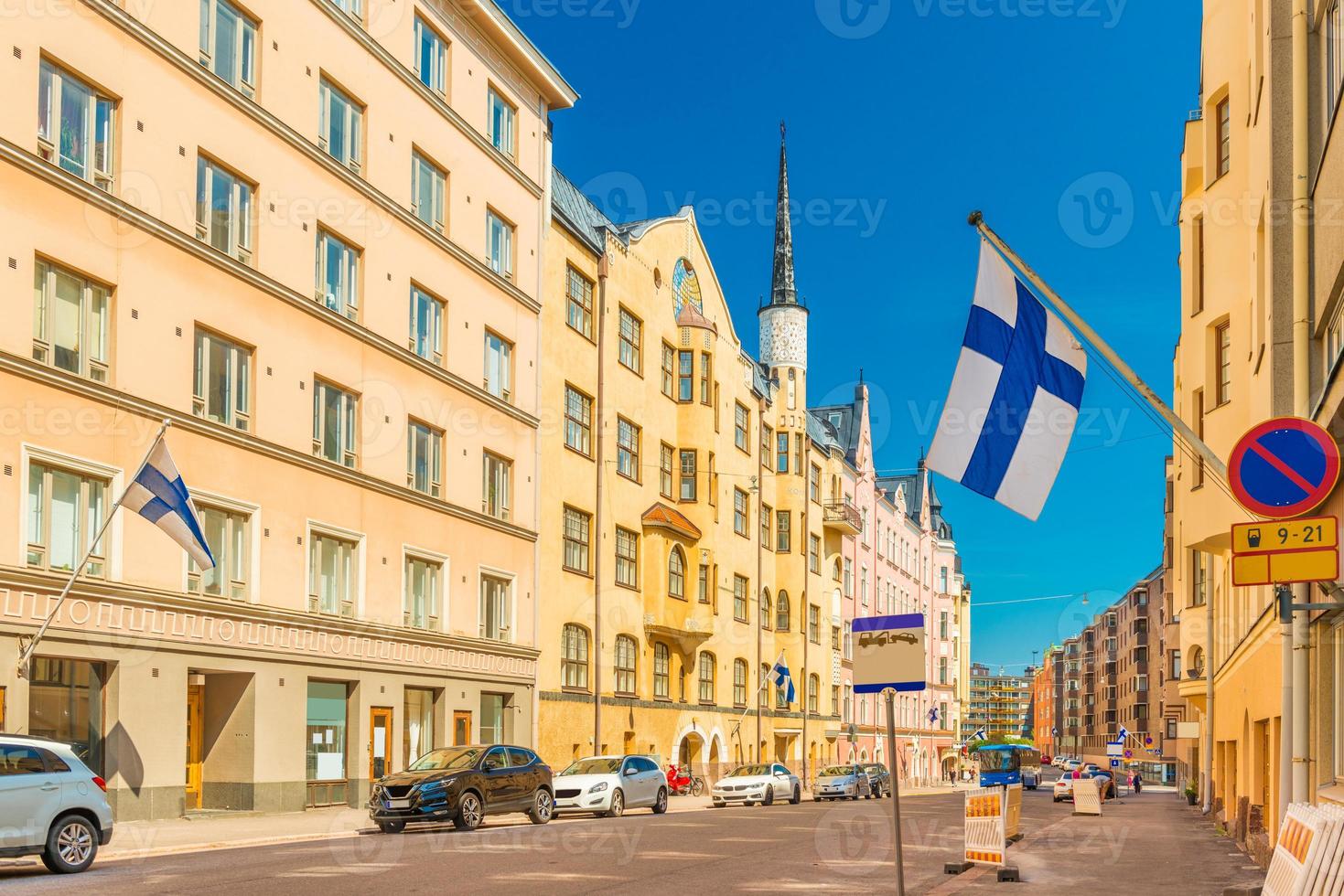 Una hermosa calle en Helsinki con coloridos edificios históricos con banderas finlandesas en las fachadas, Finlandia foto