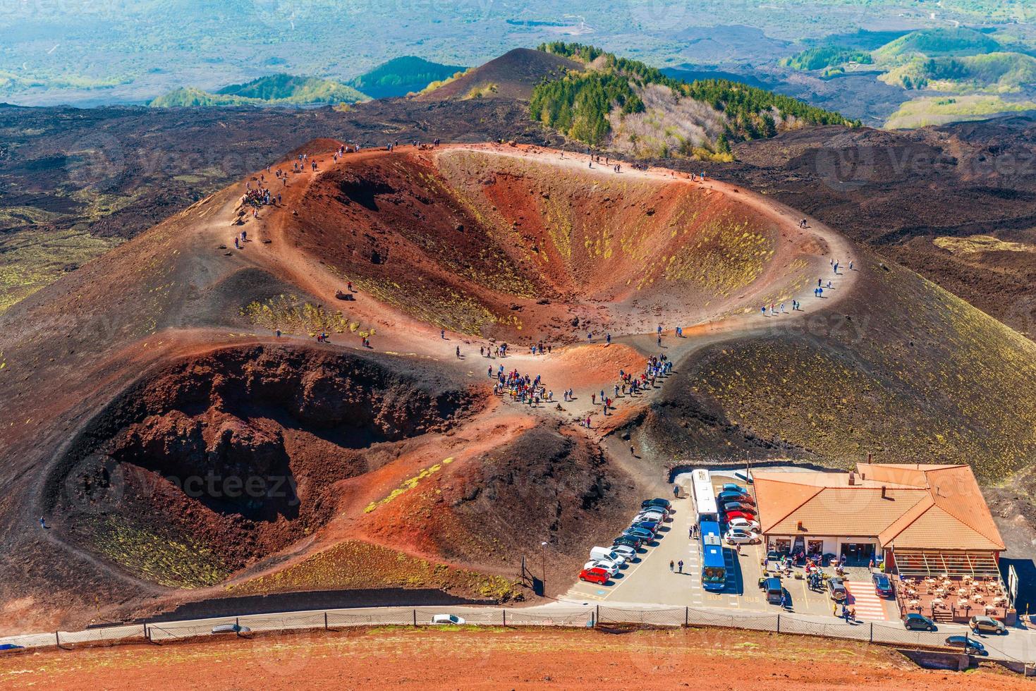 impresionante vista al cráter volcánico y grupos de turistas caminando alrededor de él. Monte Etna, Sicilia, Italia foto