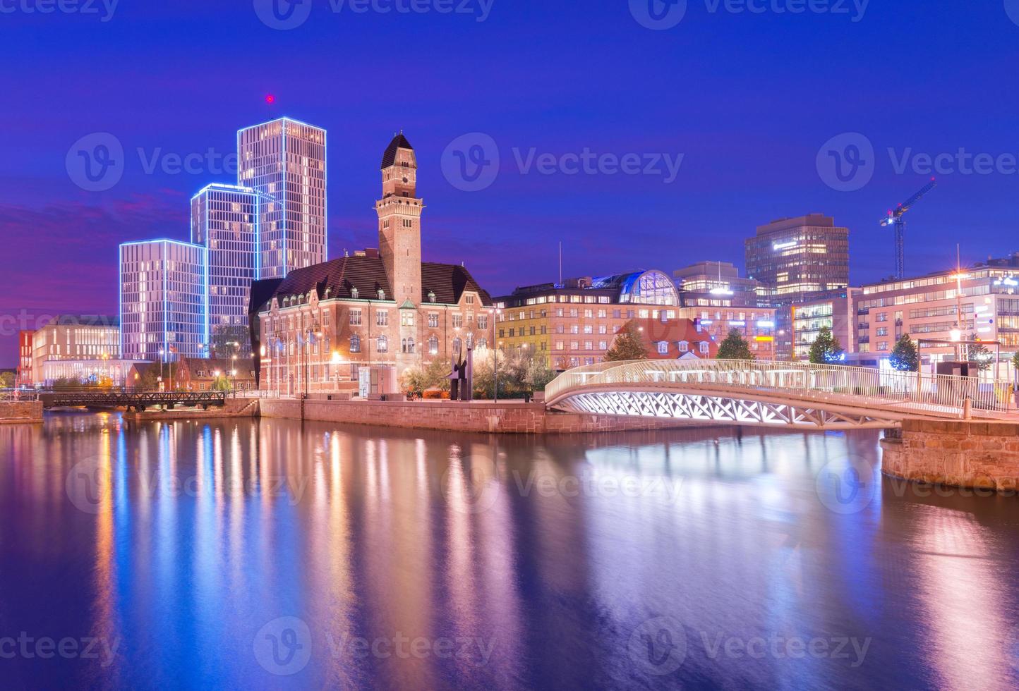 una vista de una ciudad por la noche. un panorama nocturno de malmo se refleja en el agua, suecia. foto de larga exposición con suaves reflejos agradables