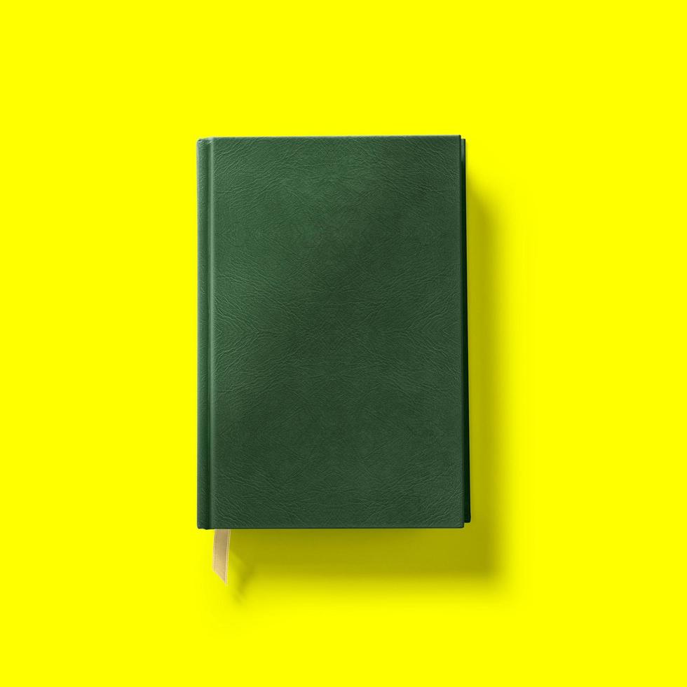 Back to school concept , hard cover dark green book front close isolated on yellow. photo