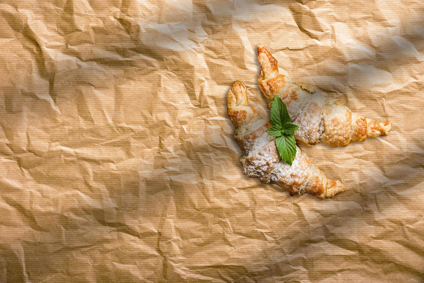 Fresh homemade croissants on baking paper. French bakery concept photo