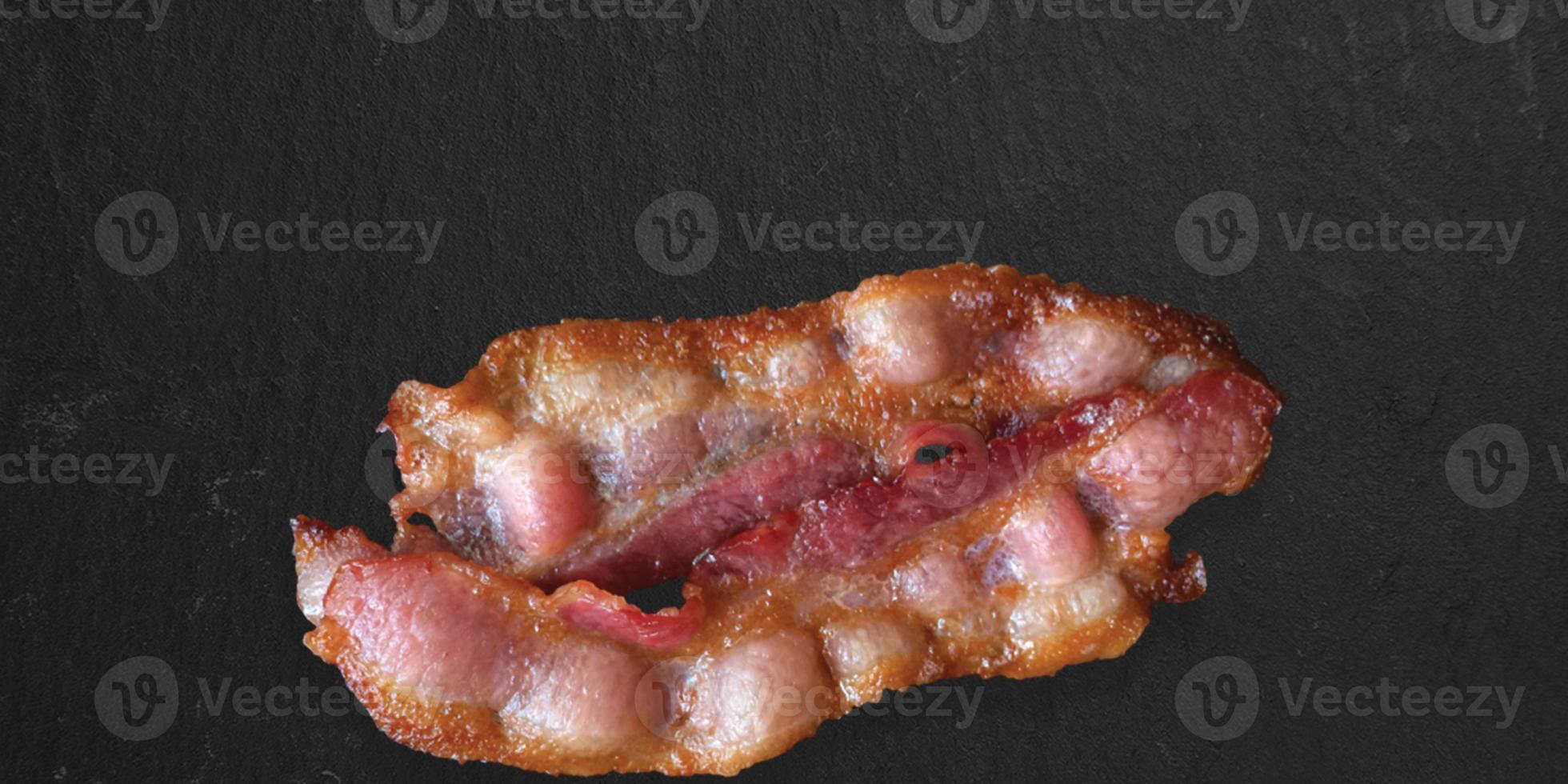 crispy thick cut smoked bacon slices isolated on dark background, close up view suitable for food design project. photo
