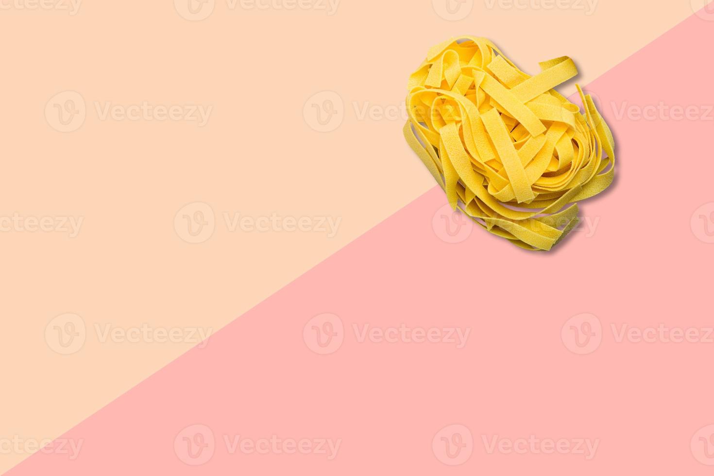 Close up view italian raw spaghetti isolated on pink background. photo