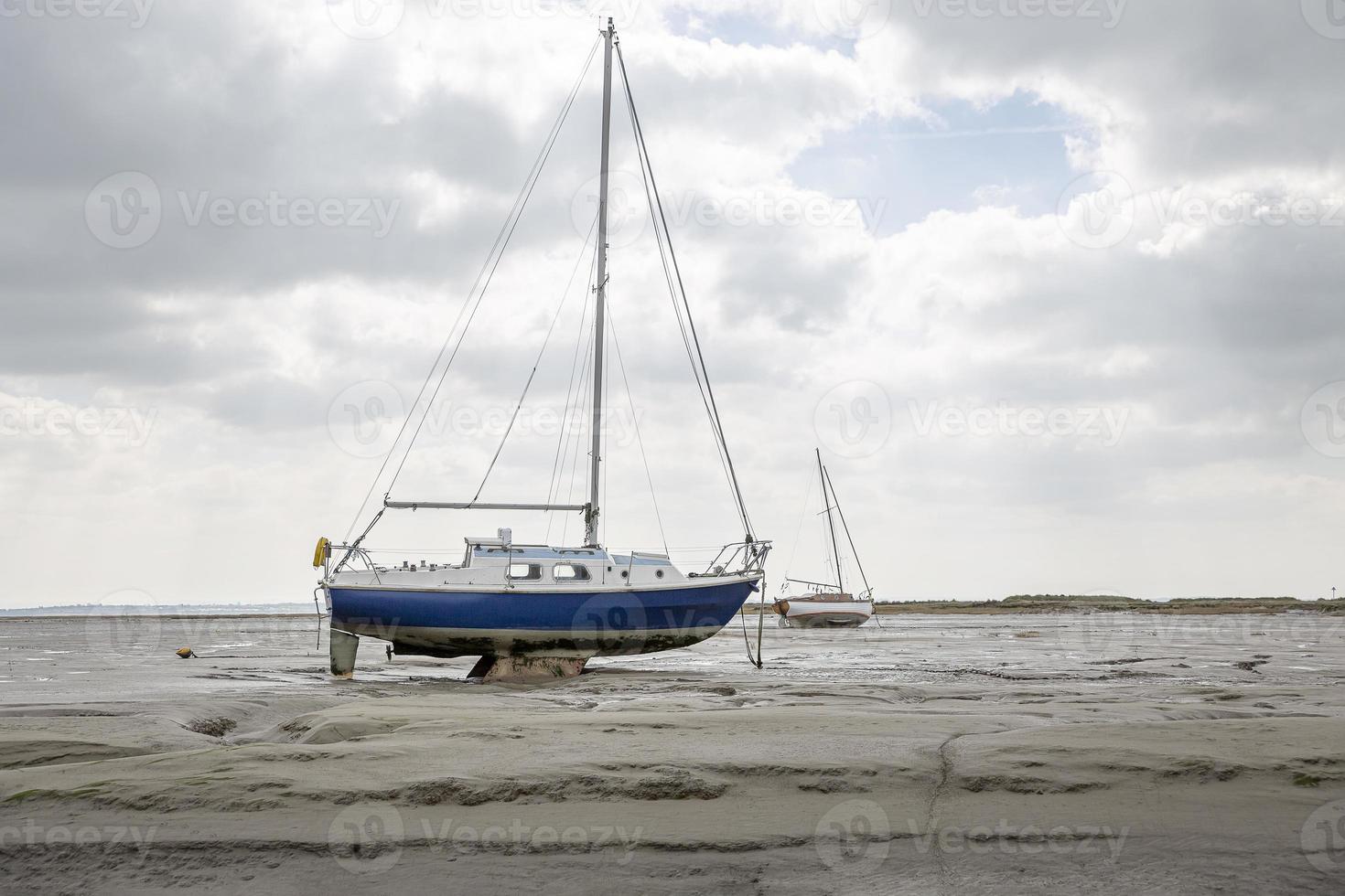 Barcos de pescadores atrapados en la playa en período de marea baja. foto