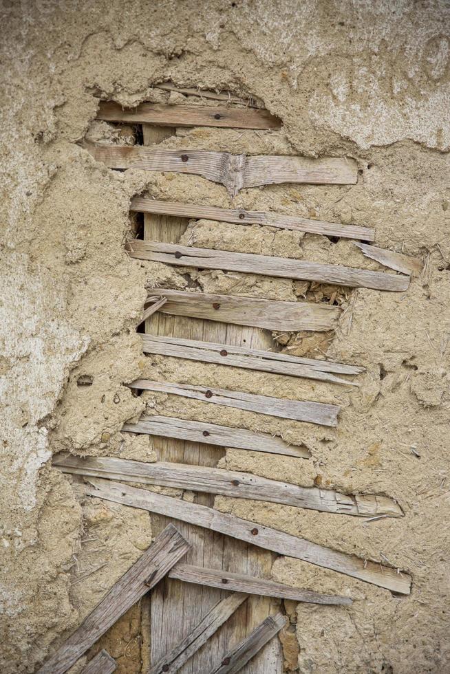 Close up of cracked adobe wall texture, clay wall from a mud house. photo
