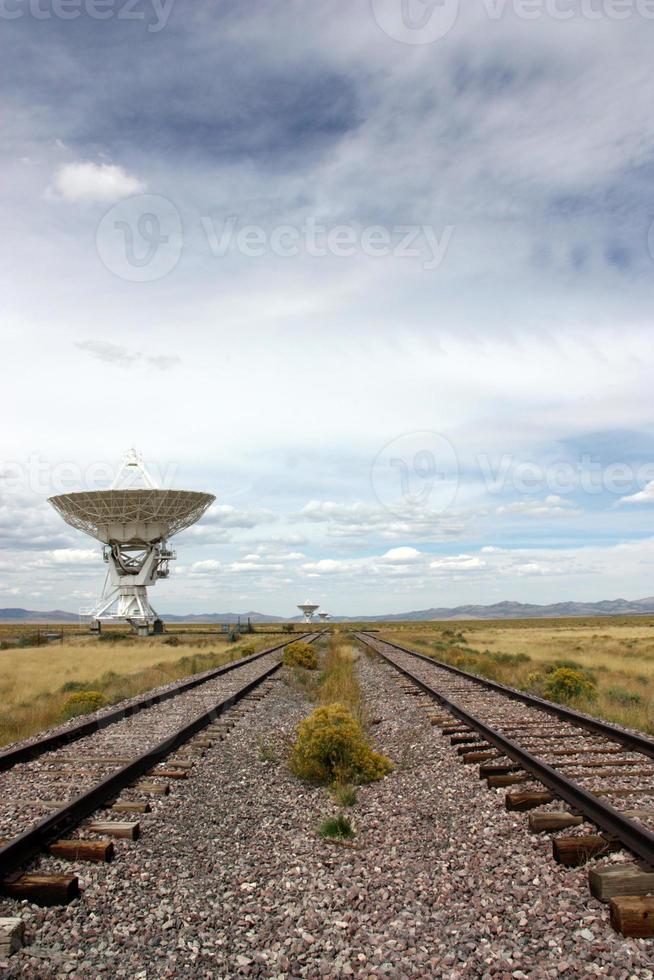 Dish from Very Large Array and old railroad tracks shows space age communication occurring with industrial age transportation photo