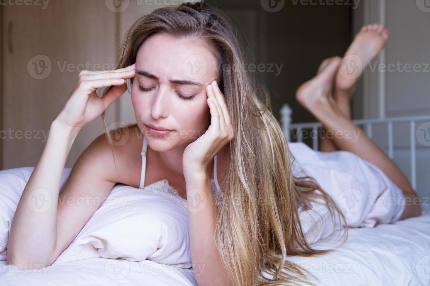 mujer joven, con, dolor de cabeza, en cama, primer plano foto