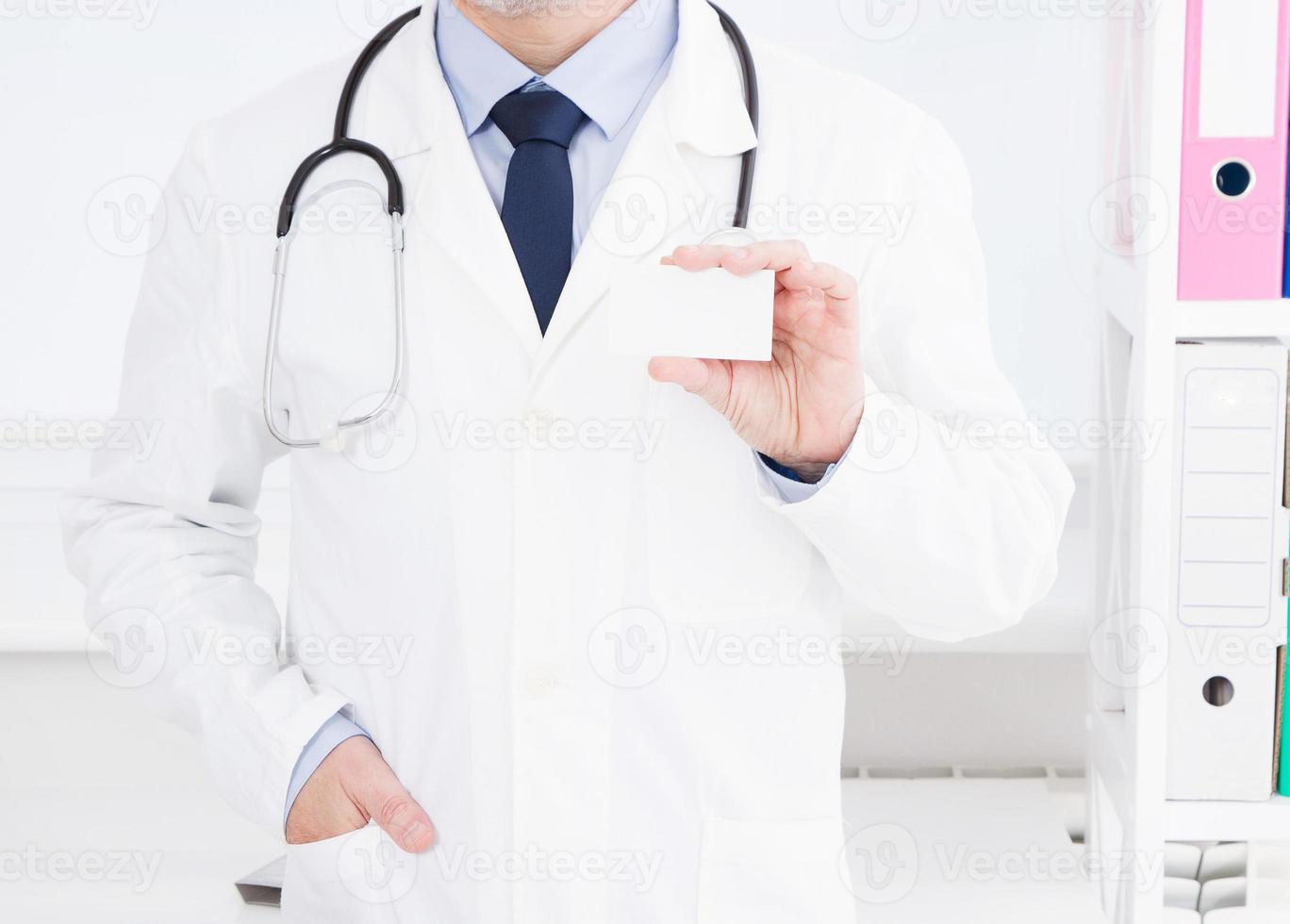 Doctor showing his business card, Medical concept, medical insurance, man in white uniform. Copy space photo