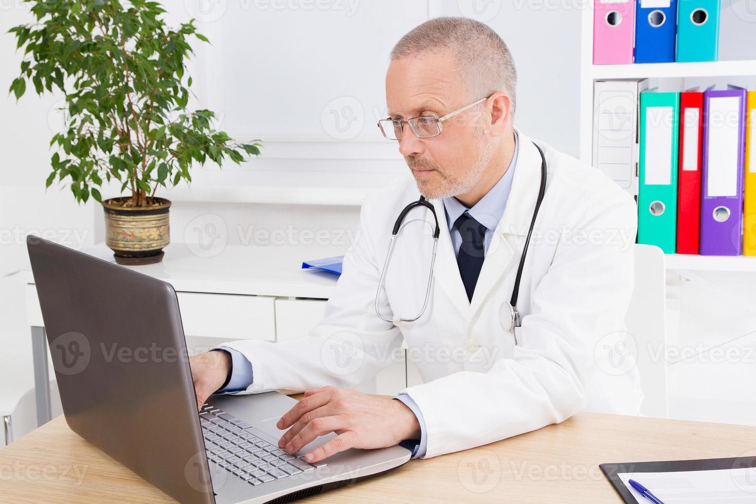 doctor works at the computer in his office in clinic photo