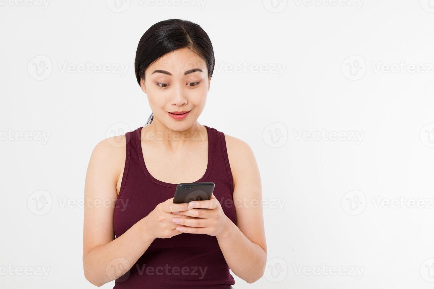 Smiling asian, japanese woman hold black smartphone, cellphone isolated on white background. Copy space. photo