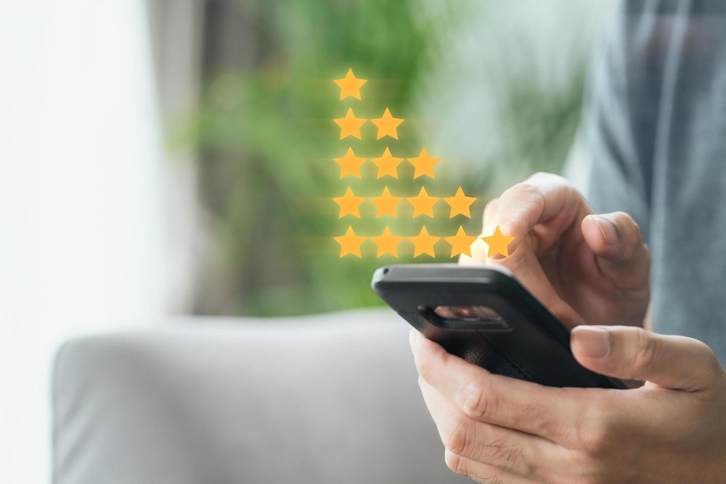 Close up of man customer giving a five star rating on smartphone. Review, Service rating, satisfaction, Customer service experience and satisfaction survey concept. photo