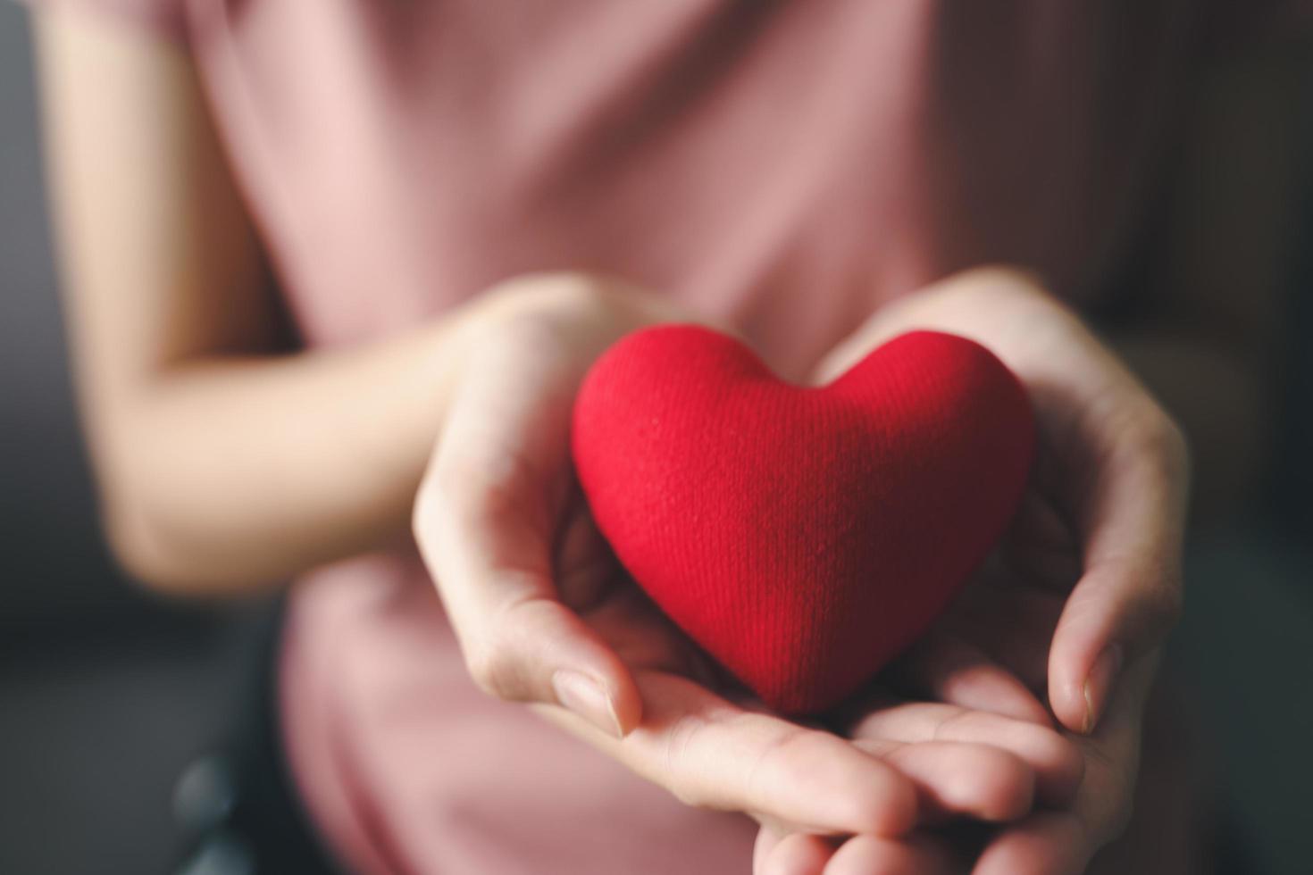 mujer sosteniendo un corazón rojo, amor, seguro médico, donación, feliz voluntario de caridad, día mundial de la salud mental, día mundial del corazón, día de san valentín foto