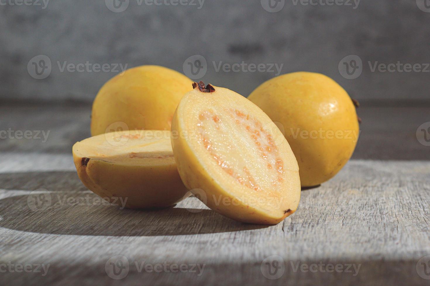 Yellow guava on wooden background. Vitamin C, healthy fruit diet. photo