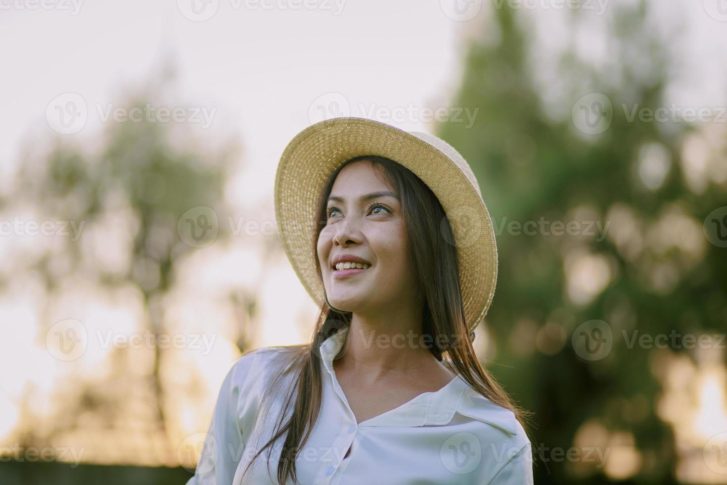 Disparo en la cabeza de la hermosa mujer con sombrero de paja y toothy sonriendo con felicidad foto