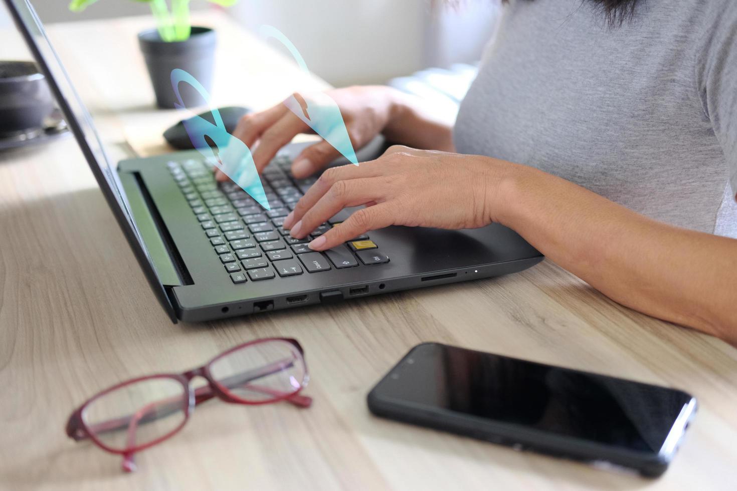 Hand typing on a laptop computer at a desk in close-up. photo