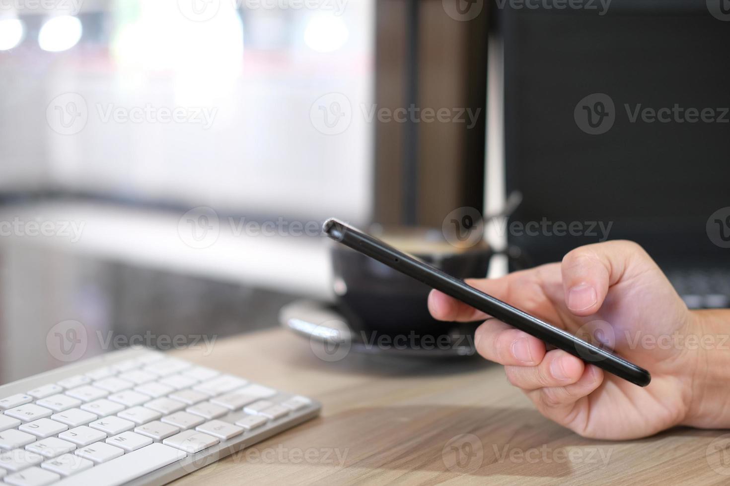 Primer plano de las manos de un hombre tomadas con un teléfono inteligente, en el café, un hombre está en su teléfono, escribiendo mensajes en las redes sociales. foto