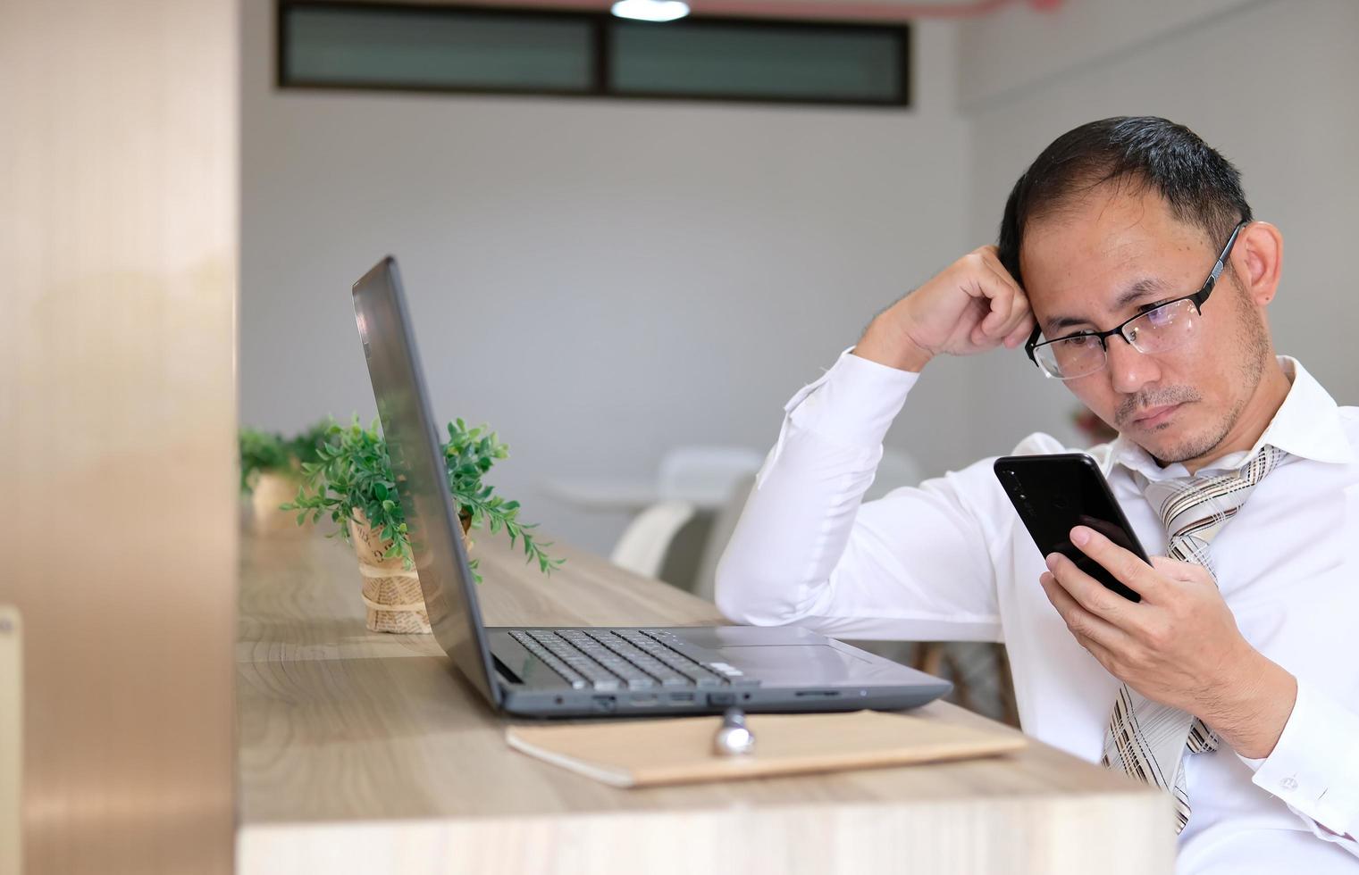 Joven empresario usando una computadora portátil en su escritorio en una oficina moderna foto