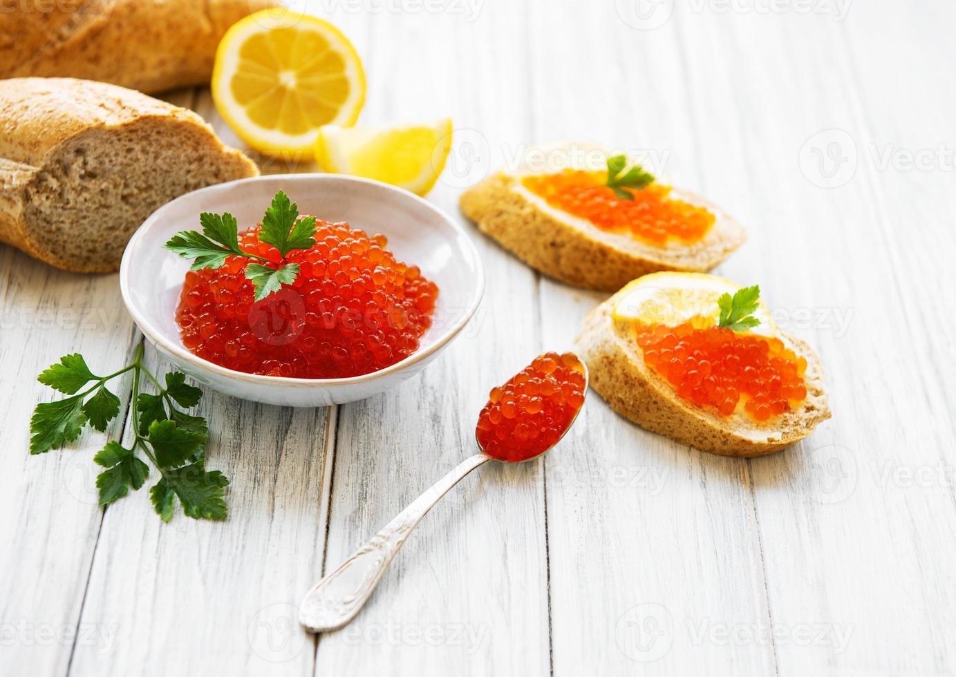 Red caviar in bowl and sandwiches photo