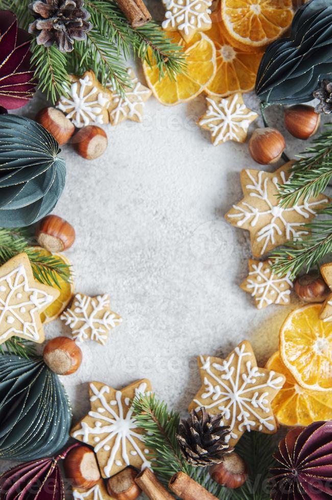 adornos navideños con borde de ramas de abeto, galletas de jengibre y bolas de papel foto