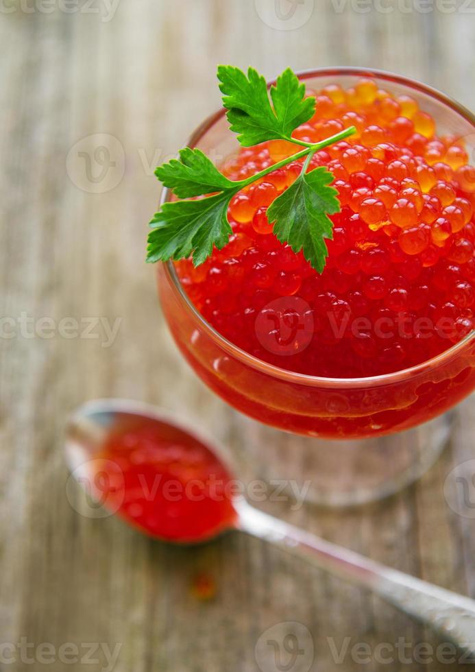 Glass with delicious red caviar photo