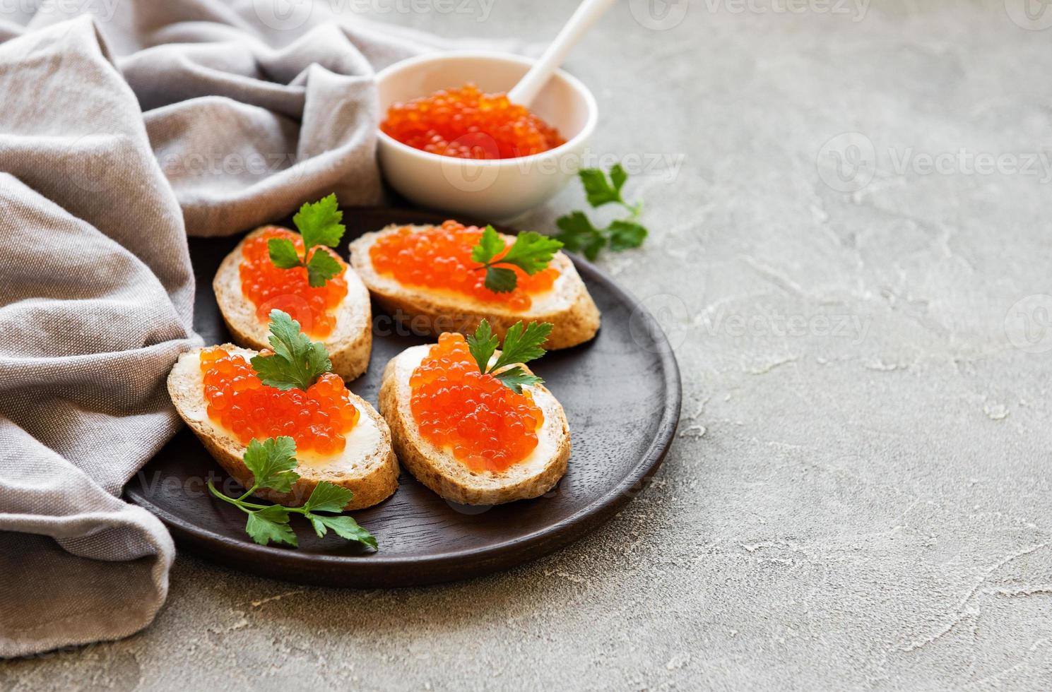 caviar rojo en tazón y bocadillos foto