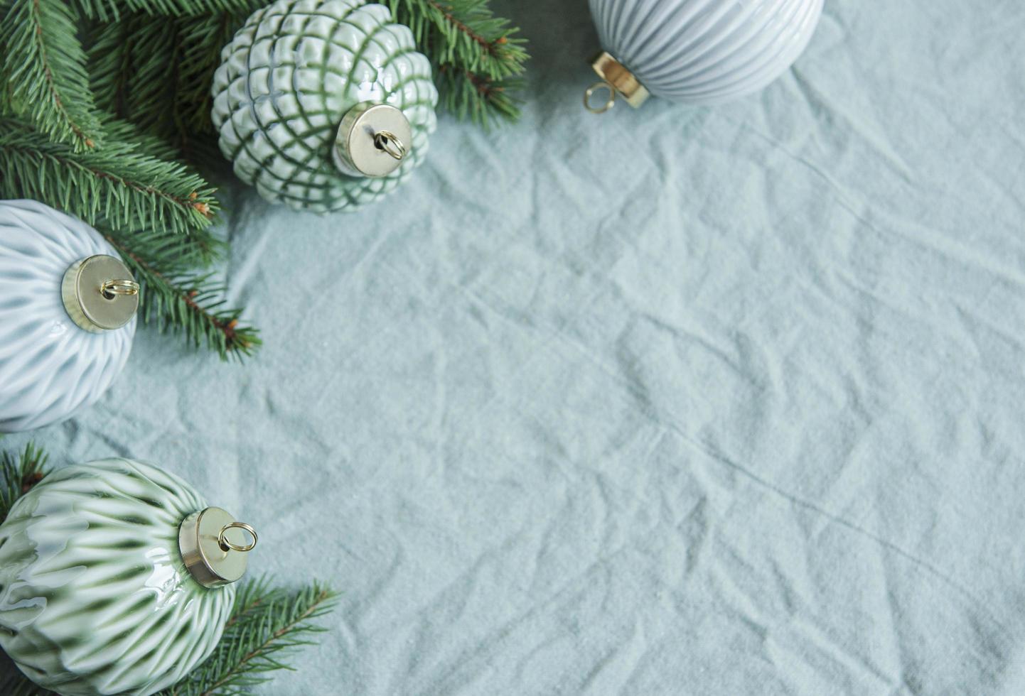 Spruce twigs with Christmas decorations on the green linen crumpled textile background photo