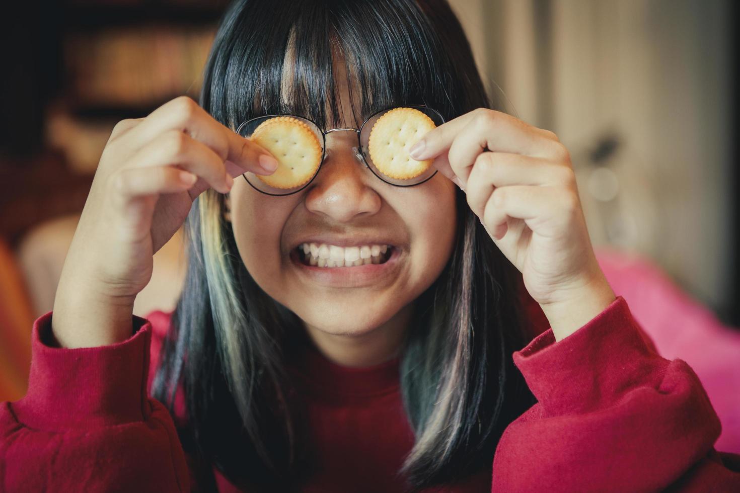 Adolescente asiático haciendo galletas de crema cerrar gafas foto