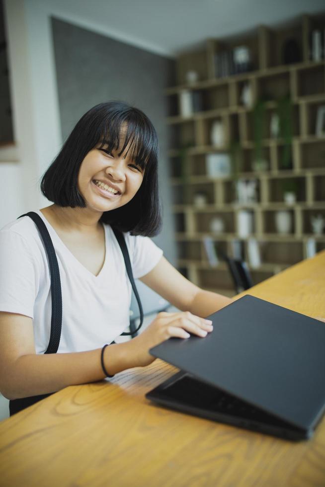 asian teenager working on computer laptop at home living room photo