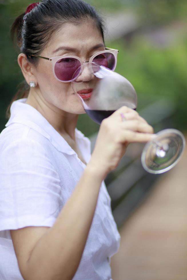 asian woman drinking red wine in luxury glass photo