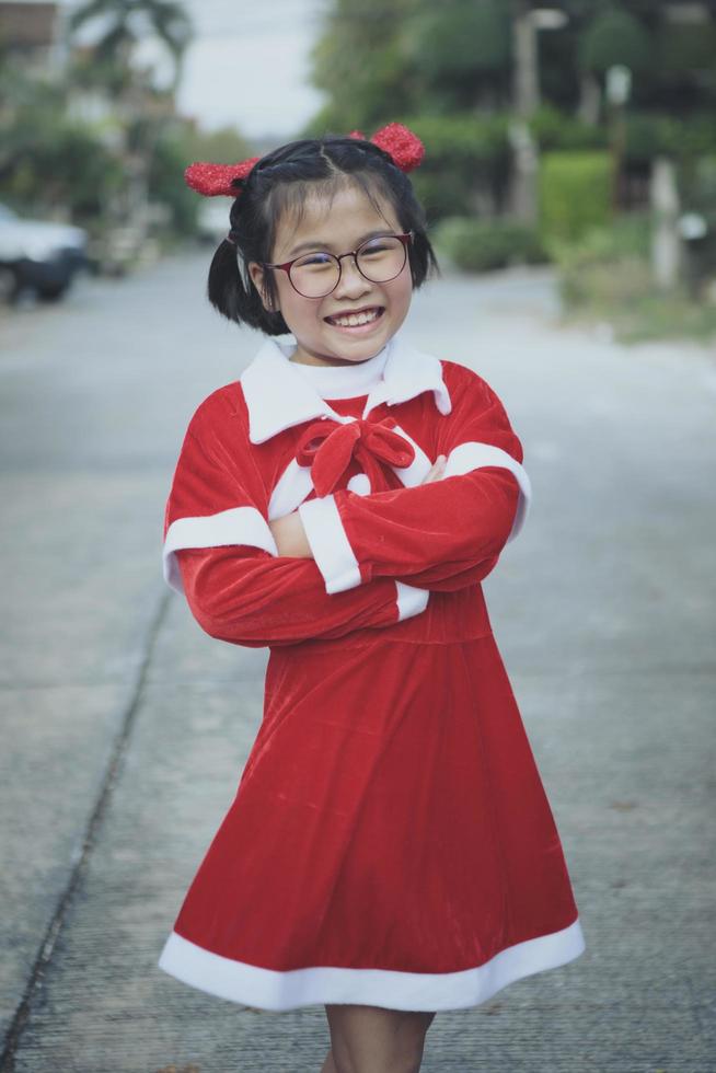 asian girl wearing red suit of santa claus toothy smiling with happiness face photo