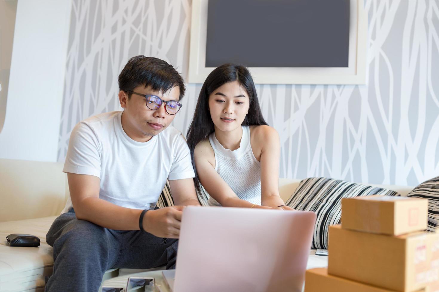 Young couple shopping online at laptop computer and pay with credit card and very happy in apartment of them. This is lifestyles of Asian young. photo
