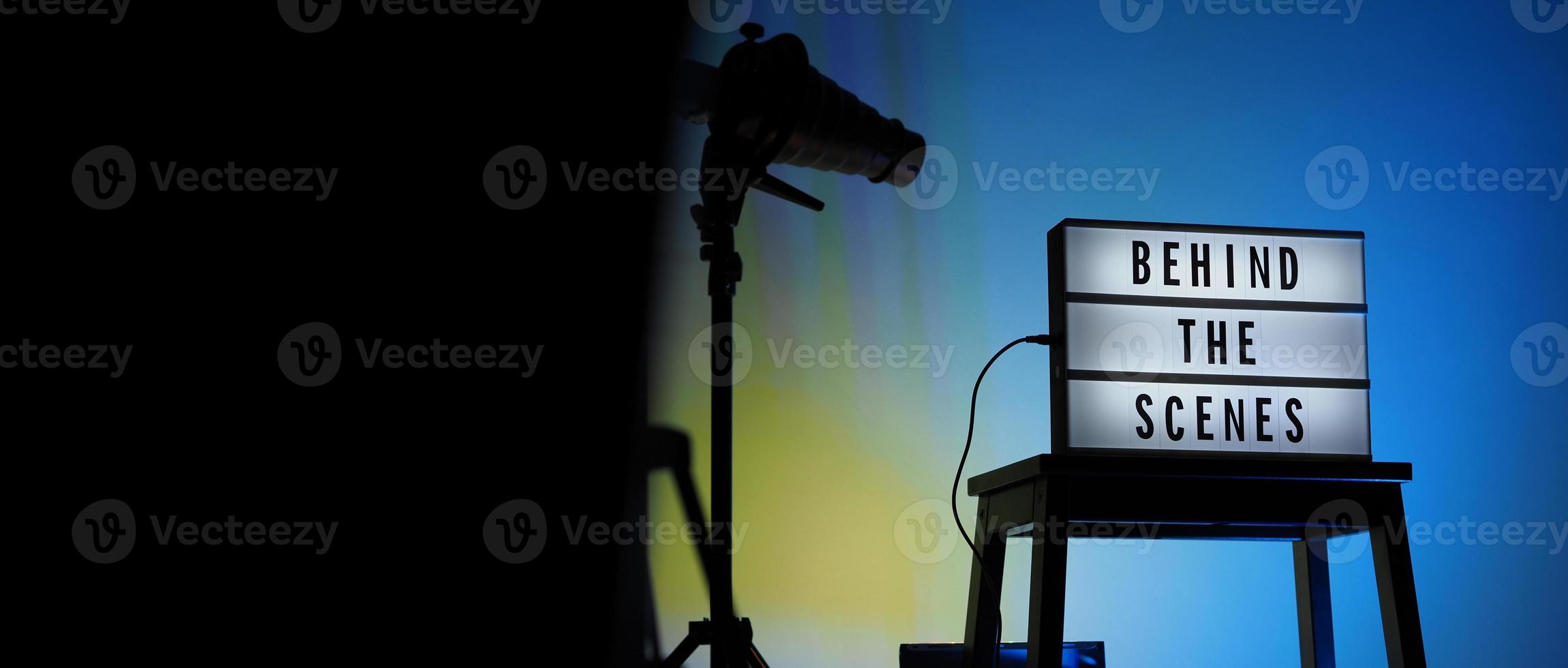 Caja de luz de tablero de película en escalera de estudio y trípode de luz snoot sobre fondo degradado de colores. foto