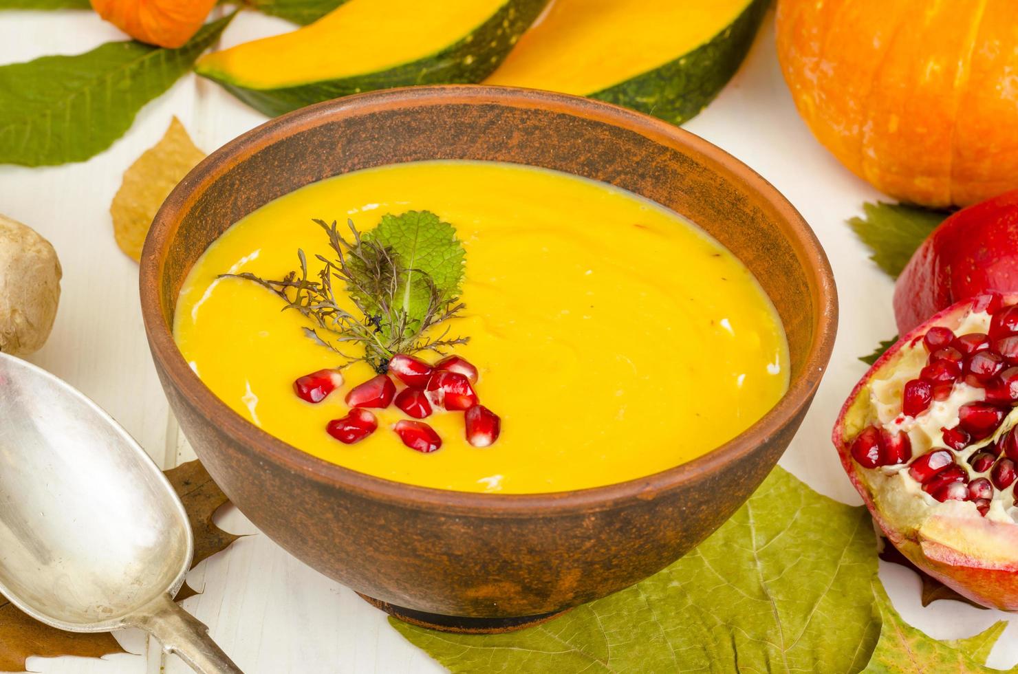 Spicy pumpkin carrot soup cream with pomegranate. photo