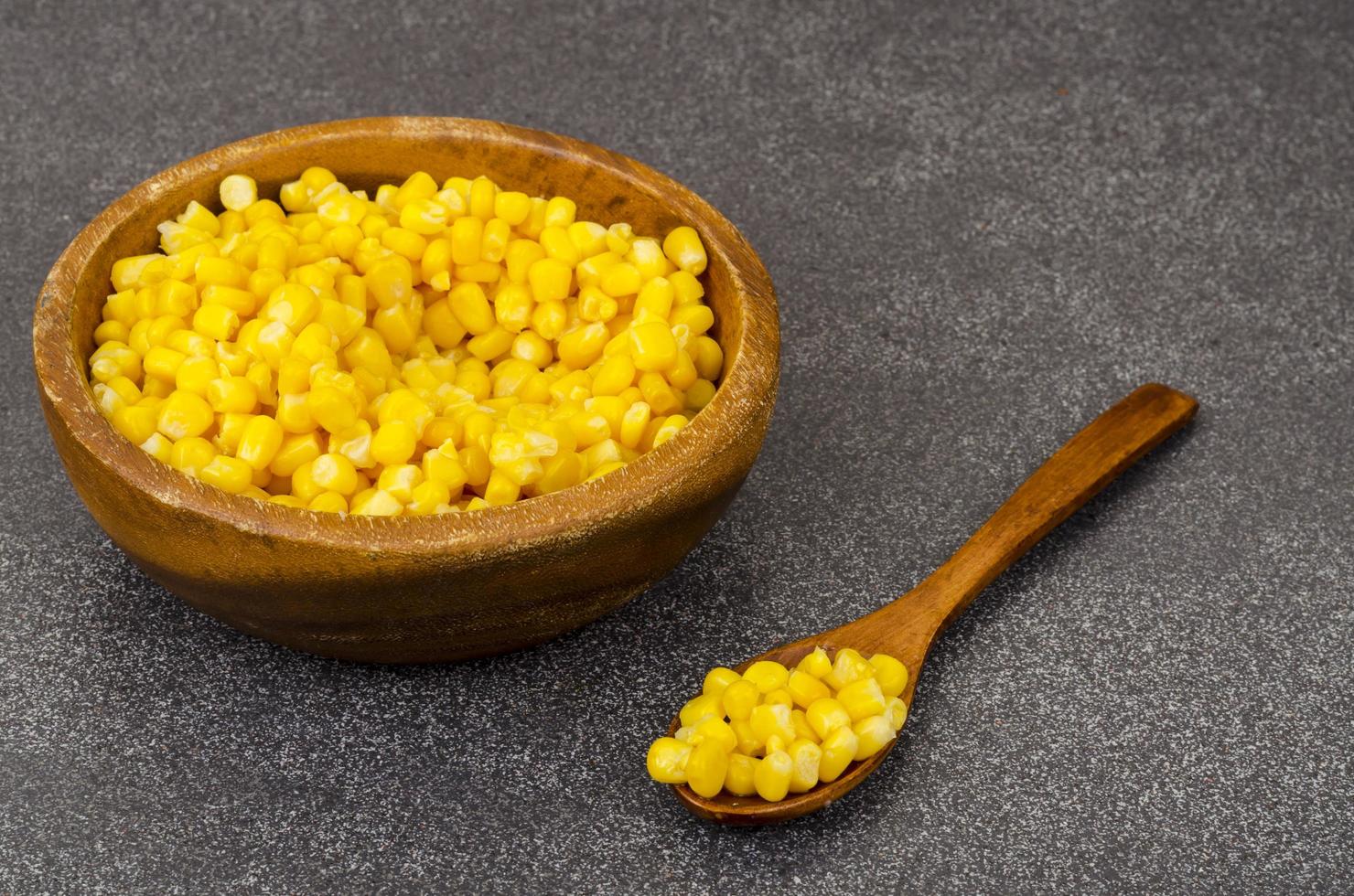 Sweet ripe canned corn in wooden bowl. photo