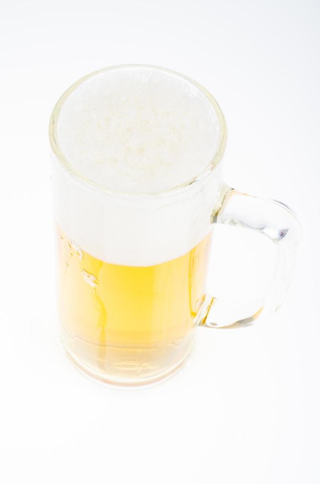 Cerveza fresca sabrosa fría con espuma en vidrio sobre fondo blanco. foto