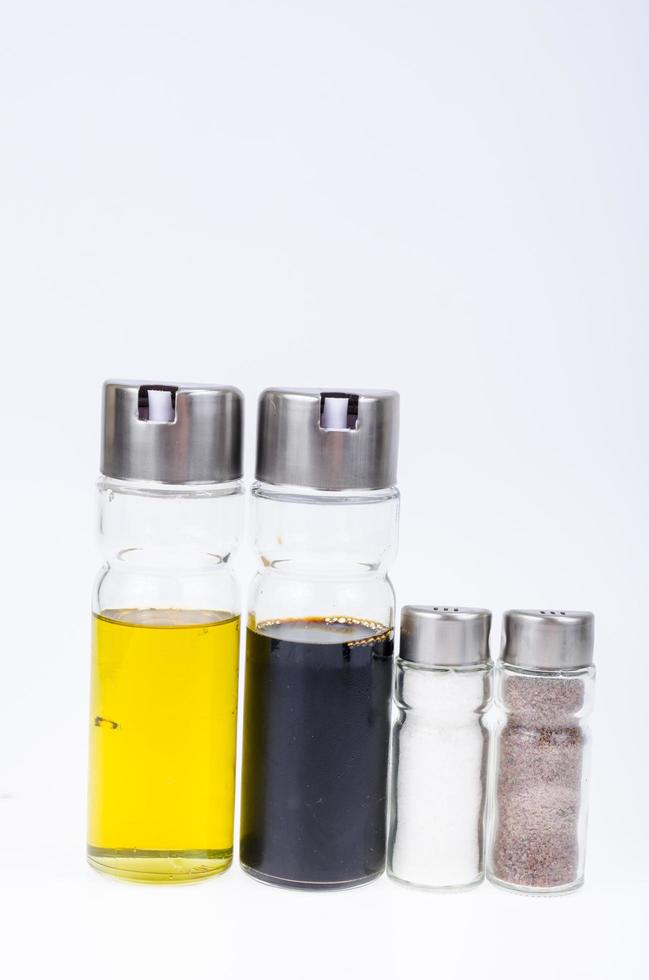 Set of glass bottles with olive oil, vinegar, salt and pepper for table setting photo