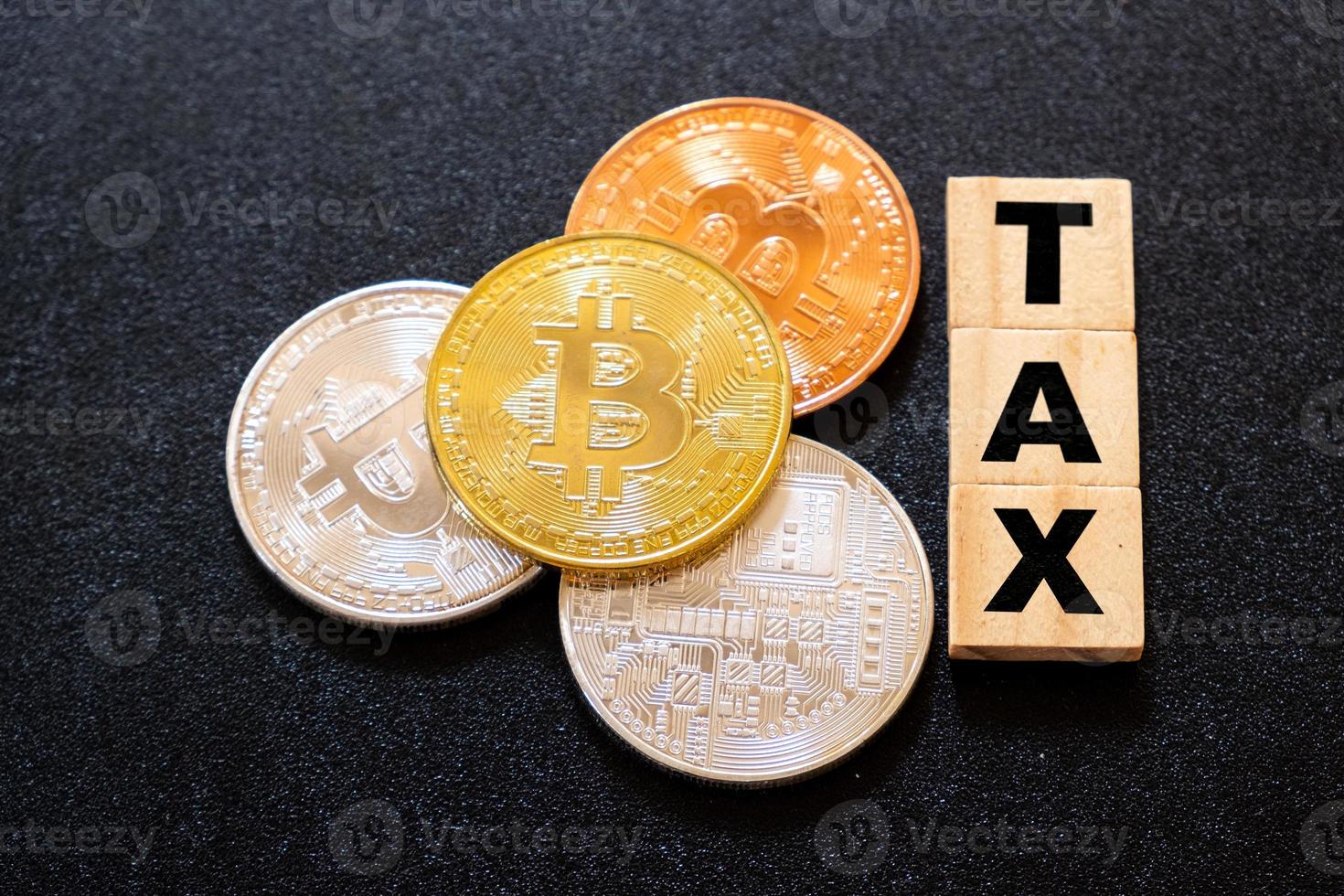 Cryptocurrencies with TAX word on dark wood background photo