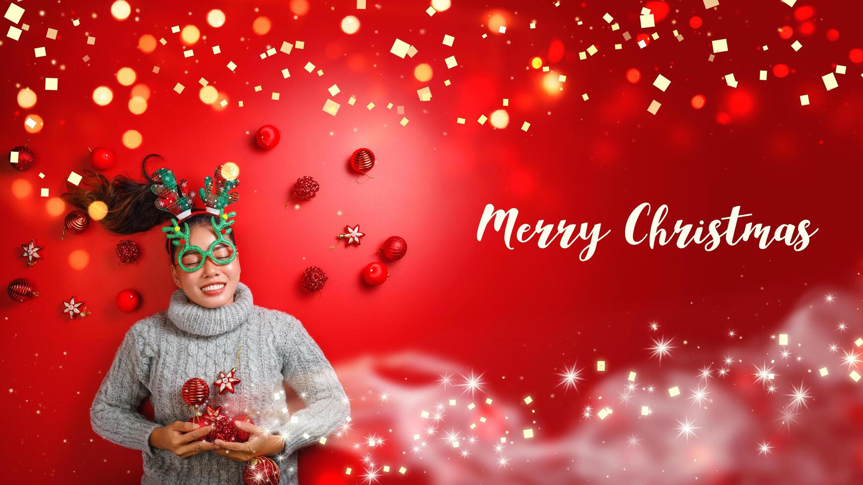 Christmas New Year. Young Woman dressed in warm sweater with  Props ball red with christmas ornaments in Holiday on shine red background. Concept merry christmas. photo