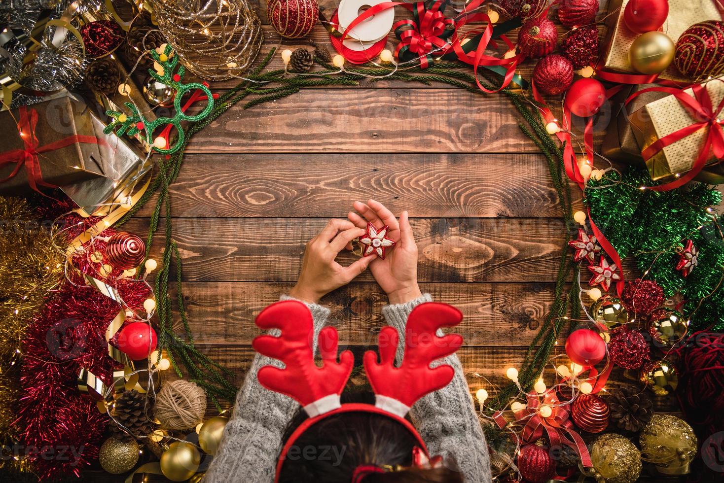 Girl laying Christmas flat composition on the wooden background with copy space for your text. Merry Christmas and Happy New Year. photo