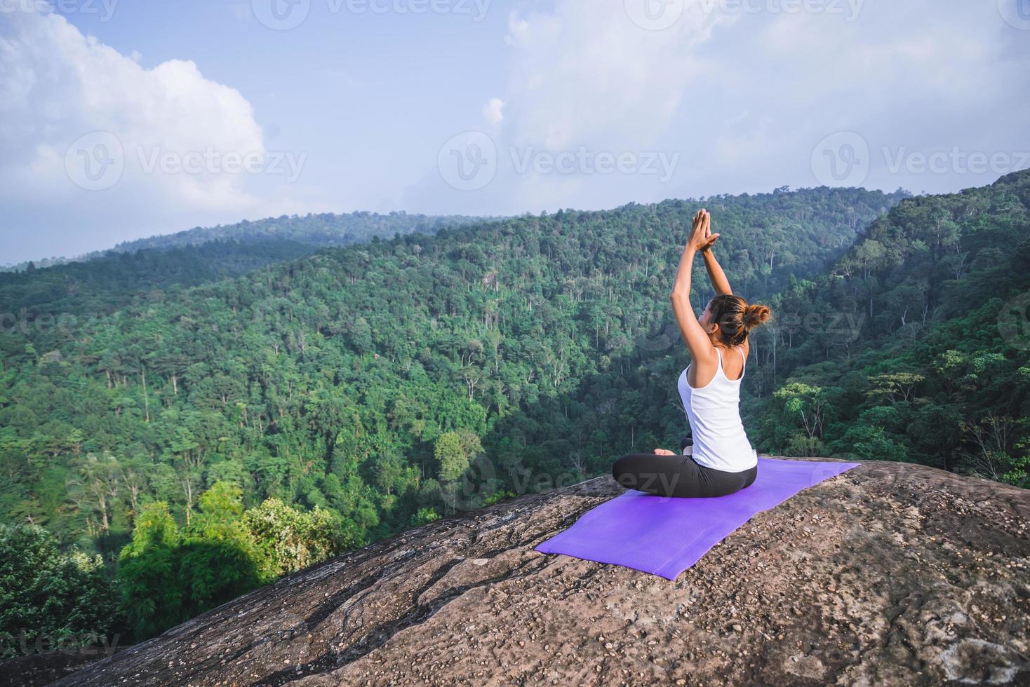 Asian women relax in the holiday. Play if yoga. On the Moutain rock cliff. Nature of mountain forests in Thailand. Young woman practicing yoga in the nature female happiness. exercise yoga photo