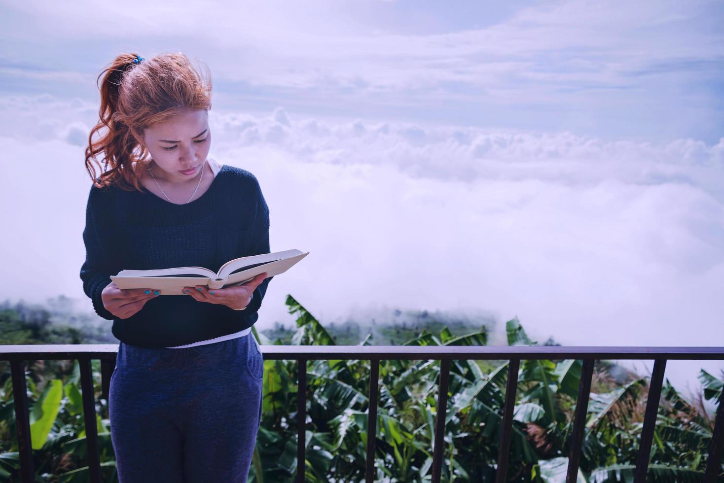 mujeres relajarse leer libro de la mañana buen tiempo cielo niebla. en las montañas, el ambiente de la mañana. foto